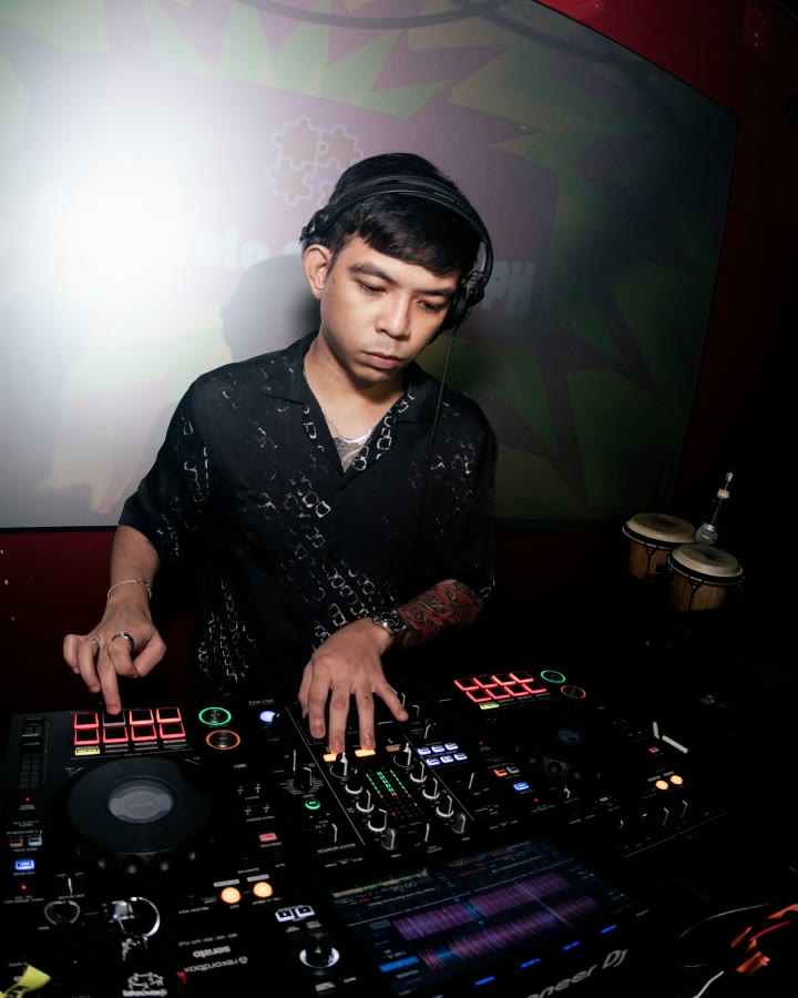 REIDEL in a red-lit booth, both hands on the controller.